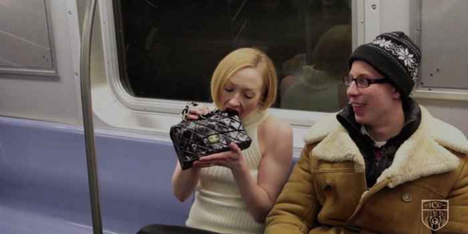 Vrouw eet handtas op in de metro voor reclamestunt