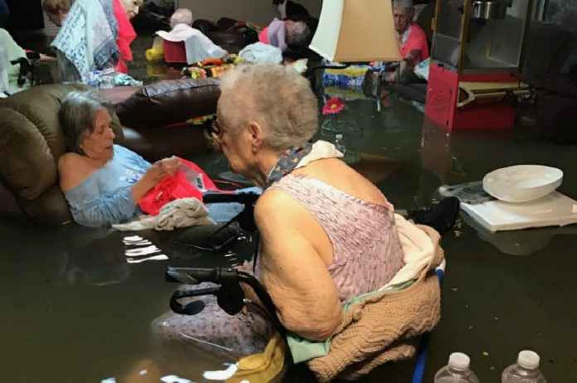 Bejaarden zitten tot hun middel in het water door storm Harvey